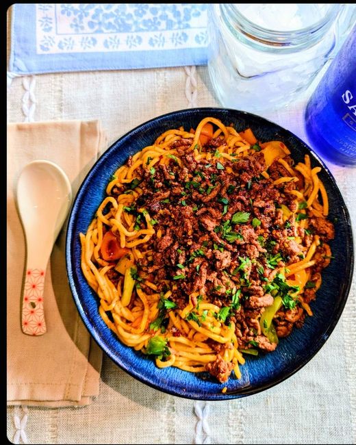 Chilli beef over garlic noodles with herbs